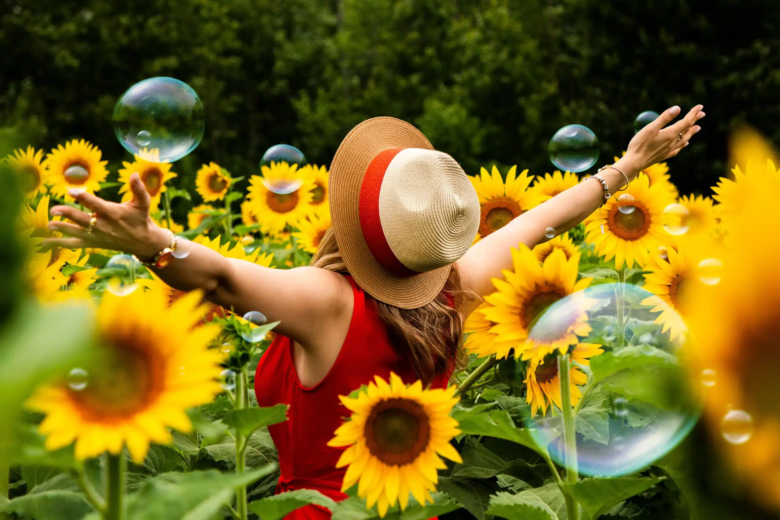 Femme profitant d'une journée ensoleillée dans un champ vibrant de tournesols avec des bulles de savon flottantes à Hamilton, Canada.